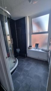 a bathroom with a shower and a window and a toilet at Boho Bliss in Swansea