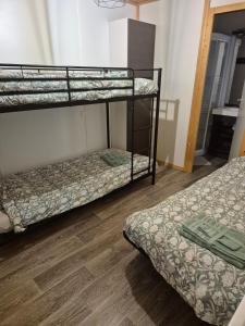 two bunk beds in a room with a wooden floor at Escapade Calme &Nature in Sulniac