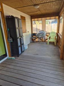 a screened in porch with a table and a refrigerator at Escapade Calme &Nature in Sulniac
