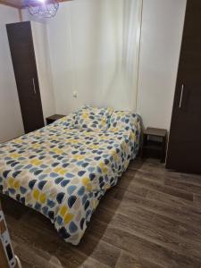 a bedroom with a bed with a blue and yellow comforter at Escapade Calme &Nature in Sulniac