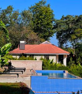 a house with a red roof and a swimming pool at NGORONGORO CORRIDOR LODGE Karatu in Karatu