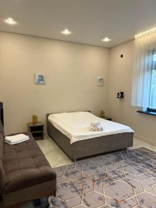a bedroom with a bed and a couch at Sherpa space in Almaty