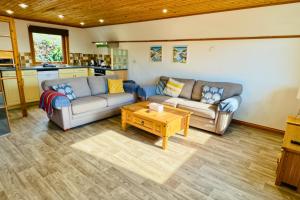 a living room with two couches and a coffee table at Lazy Bear Lodge with Hot Tub - Finlake Resort and Spa in Devon in Chudleigh