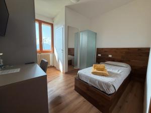 a bedroom with a bed with two towels on it at Albergo Legazzuolo Montecampione in Artogne