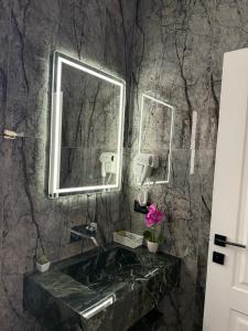 ein Badezimmer mit Waschbecken und Spiegel in der Unterkunft Hotel Muja in Rinas + 9 Fotos