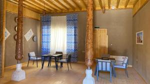 a dining room with tables and chairs in a room at Arda Angariki in Khiva