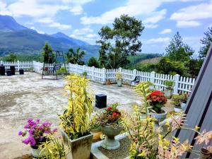 a garden with flowers and a white fence at Devilmountain kabana Kalupahana in Bandarawela