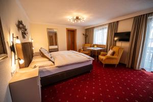 a hotel room with a bed and a living room at Pension Hartenfels in Lech am Arlberg