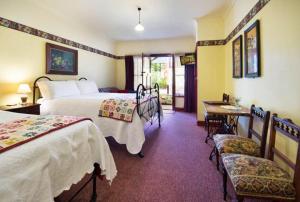 a hotel room with two beds and a table and chairs at Motel Maldon in Maldon +8 photos