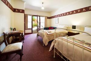 a bedroom with two bunk beds and a table and a desk at Motel Maldon in Maldon