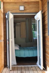an open door to a bed in a room at Valterra Lodges à Châtillon-en-Diois in Châtillon-en-Diois