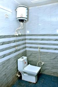 a bathroom with a toilet and a water tank at Queen Palace in Mathura