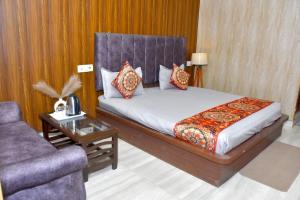 a bedroom with a bed and a couch and a table at Queen Palace in Mathura +10 photos
