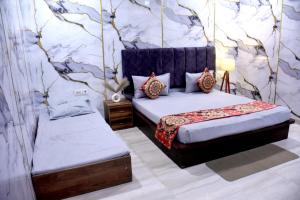 a bedroom with two beds and a wall with trees at Queen Palace in Mathura