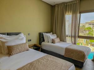 a hotel room with two beds and a window at Dominium Residence in Agadir +16 photos