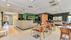 a restaurant with tables and chairs and a bar at Campanile NATURE - Moulins Avermes in Avermes +29 photos