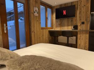 a bedroom with a bed and a desk with a sign on the wall at Studio alpin au centre de la station in Saas-Fee