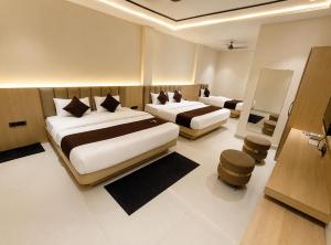 ein Hotelzimmer mit zwei Betten in einem Zimmer in der Unterkunft Hotel Mewada in Ujjain