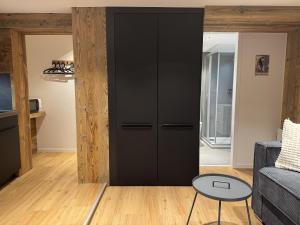 a black closet in a living room with a couch at Studio alpin au centre de la station in Saas-Fee