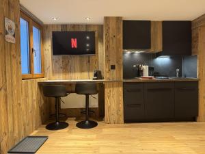 a kitchen with a bar with a tv on the wall at Studio alpin au centre de la station in Saas-Fee +4 photos