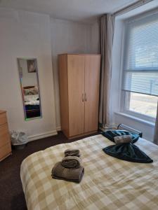 a bedroom with a bed with two towels on it at Boho Bliss in Swansea