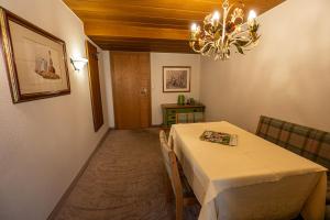 a dining room with a table and a chandelier at Pension Hartenfels in Lech am Arlberg
