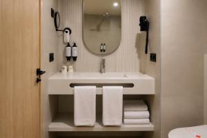 a bathroom with a sink and a mirror and towels at AR Roca Esmeralda & SPA Hotel in Calpe +41 photos