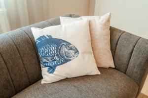 a pillow with a fish on it sitting on a couch at Boven restaurant de Babbelaar 1 in Oostkapelle