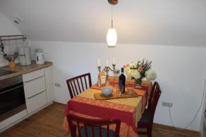 a dining room table with a red table cloth and candles at Schenkenhof Proitze in Schnega +2 photos
