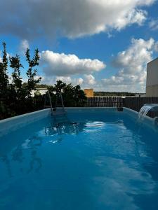 a large blue swimming pool with a water fountain at פינוק של סוויטה in Manot