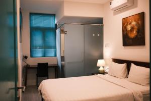 a bedroom with a bed and a desk and a window at Saigon Holiday House in Ho Chi Minh City