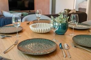 a wooden table with plates and wine glasses on it at Boven restaurant de Babbelaar 2 in Oostkapelle