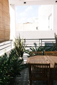 a patio with a wooden table and chairs and plants at Saigon Holiday House in Ho Chi Minh City