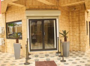 a front door of a building with two potted plants at Hotel St Flavien Lomé in Taméklo