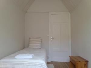 a small bedroom with a bed and a door at Villa Signerose - chambres chez l'habitant au cœur de l'Ardèche - Hautes vallées in Le Cheylard