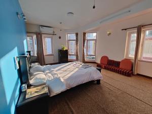 a large bedroom with a large bed and windows at Peace Home Apartment Swayambhu in Kathmandu
