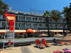 a hotel on the beach with chairs and umbrellas at Alevok Hotel in Erdek
