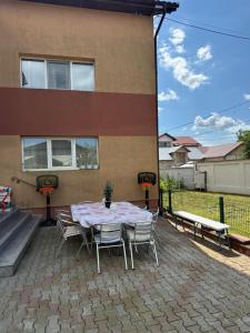a table and chairs on a patio in front of a building at Harmony House Vera Lux in Dragomireşti