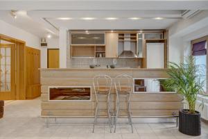a kitchen with two stools in front of a counter at Cozy Apartment Floreasca Park in Bucharest