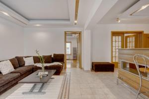 a living room with a couch and a table at Cozy Apartment Floreasca Park in Bucharest