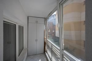 an empty room with a window and a balcony at Cozy Apartment Floreasca Park in Bucharest