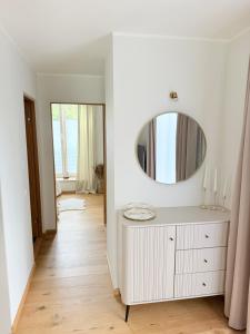 a white bathroom with a mirror and a dresser at Liiva apartement Kärdla in Kärdla