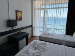 a hotel room with two beds and a window at Alevok Hotel in Erdek