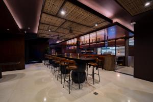 a bar in a restaurant with a long bar stools at Nuju Uluwatu - Adults Only in Uluwatu