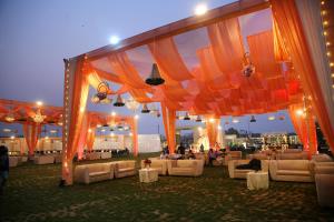 a marquee with couches and chairs at a wedding at Bhola Resort in Soraon