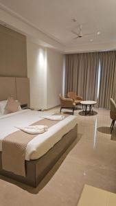 a bedroom with a bed and chairs and a table at Bhola Resort in Soraon +102 photos