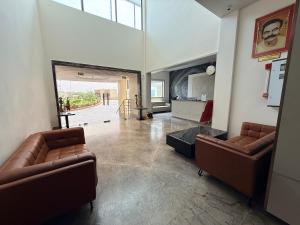 a living room with two leather chairs and a mirror at Bhola Resort in Soraon