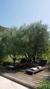 two beds on a wooden deck under trees at A l'orée du bois - Chambres d'hôtes in Hostun +10 photos