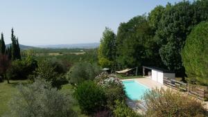 a swimming pool in a garden with trees at A l'orée du bois - Chambres d'hôtes in Hostun