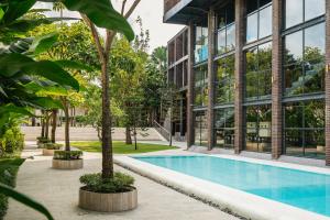 a building with a swimming pool in front of a building at ONYX PARK RESORT Ubud in Ubud